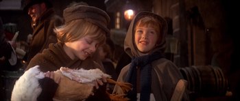 Movie still from “Scrooge” (1970), directed by Ronald Neame – Two children dressed in medieval clothing eating food; Close Up shot, Over the shoulder angle