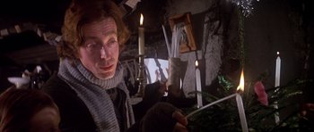 Movie still from “Scrooge” (1970), directed by Ronald Neame – A woman is lighting a candle in a room; Close Up shot, Low angle