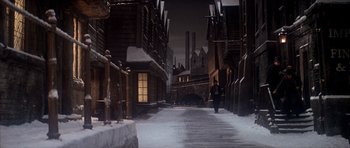 Movie still from “Scrooge” (1970), directed by Ronald Neame – A man walking down a snowy street at night; Extreme Wide shot, High angle