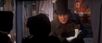 Movie still from “Scrooge” (1970), directed by Ronald Neame – An older man wearing a top hat in a room; Medium shot, Over the shoulder angle