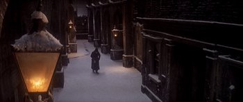Movie still from “Scrooge” (1970), directed by Ronald Neame – A person walking in the snow near a building; Extreme Wide shot, High angle