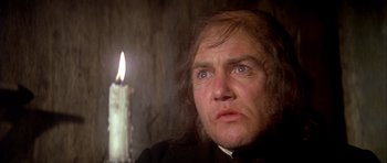 Movie still from “Scrooge” (1970), directed by Ronald Neame – A man with a candle in the dark; Close Up shot, Low angle