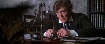 Movie still from “Scrooge” (1970), directed by Ronald Neame – A man sitting at a desk with a pen and ink; Close Up shot, Low angle