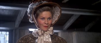 Movie still from “Scrooge” (1970), directed by Ronald Neame – A woman wearing a hat and a dress; Close Up shot, Low angle