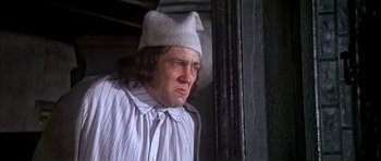 Movie still from “Scrooge” (1970), directed by Ronald Neame – A man wearing a white hat and a striped shirt; Close Up shot, Low angle