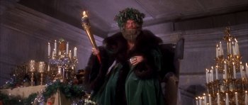 Movie still from “Scrooge” (1970), directed by Ronald Neame – A man dressed in green holding a lit candle; Medium shot, Low angle