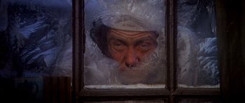 Movie still from “Scrooge” (1970), directed by Ronald Neame – An old man looking through a window with ice; Close Up shot, High angle