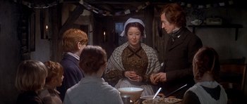 Movie still from “Scrooge” (1970), directed by Ronald Neame – A group of people sitting around a table; Medium shot, Over the shoulder angle