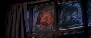 Movie still from “Scrooge” (1970), directed by Ronald Neame – A man with a long beard and a white beard is looking through a window; Close Up shot, High angle