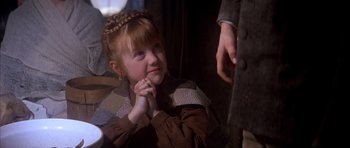 Movie still from “Scrooge” (1970), directed by Ronald Neame – A little girl sitting on the ground with her hand on her chin; Close Up shot, Over the shoulder angle
