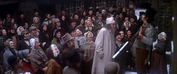 Movie still from “Scrooge” (1970), directed by Ronald Neame – A group of people in a crowd of people wearing hats; Wide shot, High angle