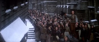 Movie still from “Scrooge” (1970), directed by Ronald Neame – A group of people standing next to each other on a street; Extreme Wide shot, High angle