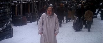 Movie still from “Scrooge” (1970), directed by Ronald Neame – An old man in a white robe is standing in the snow; Medium shot, High angle