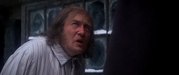 Movie still from “Scrooge” (1970), directed by Ronald Neame – An old man with long hair and a tie; Close Up shot, Over the shoulder angle
