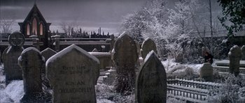 Movie still from “Scrooge” (1970), directed by Ronald Neame – A cemetery with a bunch of tombstones in the snow; Wide shot, High angle