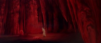 Movie still from “Scrooge” (1970), directed by Ronald Neame – A man in a white robe walks through a cave; Extreme Wide shot, High angle