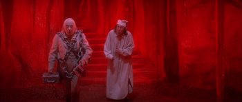 Movie still from “Scrooge” (1970), directed by Ronald Neame – A man and a woman dressed in costumes on a stage; Wide shot, High angle