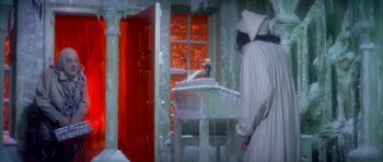 Movie still from “Scrooge” (1970), directed by Ronald Neame – A person standing in front of an open door; Wide shot, High angle