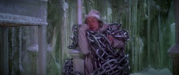 Movie still from “Scrooge” (1970), directed by Ronald Neame – A man in a hat and a bunch of chains; Medium shot, High angle