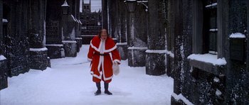 Movie still from “Scrooge” (1970), directed by Ronald Neame – A man dressed as santa claus standing in the snow; Wide shot, High angle