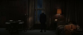 Movie still from “1899” (2022), created by Jantje Friese – A man standing in front of a window in a dark room; Wide shot, High angle