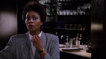 Movie still from “Scrooged” (1988), directed by Richard Donner – A woman sitting in front of a counter in front of a bar; Close Up shot, Low angle