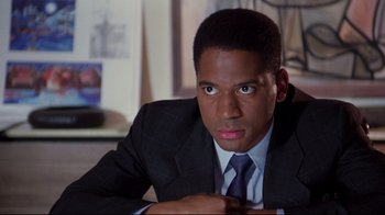 Movie still from “Scrooged” (1988), directed by Richard Donner – A person wearing a suit and tie; Close Up shot, Over the shoulder angle