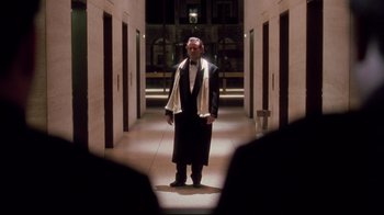 Movie still from “Scrooged” (1988), directed by Richard Donner – A man standing in a hallway wearing a robe; Wide shot, Low angle