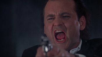 Movie still from “Scrooged” (1988), directed by Richard Donner – A person holding a gun; Close Up shot, Low angle