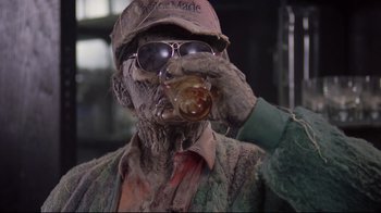 Movie still from “Scrooged” (1988), directed by Richard Donner – A man in a hat and sunglasses holding a glass of beer; Close Up shot, Low angle