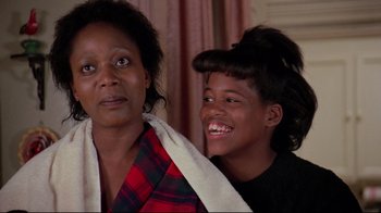 Movie still from “Scrooged” (1988), directed by Richard Donner – A woman and a boy smile for the camera; Close Up shot, Over the shoulder angle