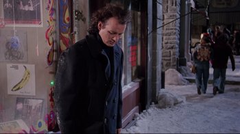 Movie still from “Scrooged” (1988), directed by Richard Donner – A man standing in front of a building in the snow; Medium shot, Low angle