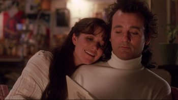 Movie still from “Scrooged” (1988), directed by Richard Donner – A man and a woman are smiling for the camera; Close Up shot, Low angle