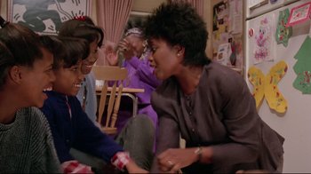 Movie still from “Scrooged” (1988), directed by Richard Donner – A group of people sitting in a living room; Medium shot, Over the shoulder angle