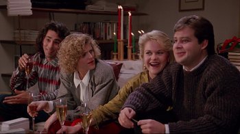 Movie still from “Scrooged” (1988), directed by Richard Donner – A group of people sitting on a couch with wine glasses; Medium shot, High angle
