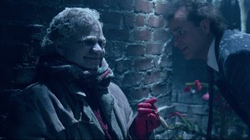 Movie still from “Scrooged” (1988), directed by Richard Donner – A man with a cigarette in his mouth and a woman with a red glove; Close Up shot, Over the shoulder angle