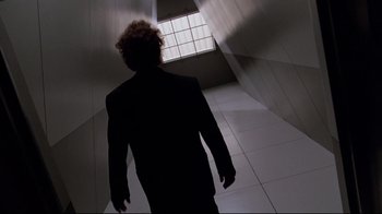 Movie still from “Scrooged” (1988), directed by Richard Donner – A man in a suit walking down a hall way; Medium shot, Low angle