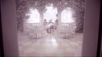 Movie still from “Scrooged” (1988), directed by Richard Donner – Two women sitting at a table in front of a window; Wide shot, High angle