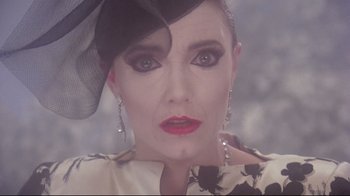 Movie still from “Scrooged” (1988), directed by Richard Donner – A person wearing a dress and a hat; Close Up shot, High angle