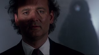 Movie still from “Scrooged” (1988), directed by Richard Donner – A person wearing a suit and tie; Close Up shot, Low angle