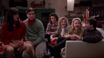 Movie still from “Scrooged” (1988), directed by Richard Donner – A group of people sitting in a living room together; Medium shot, High angle