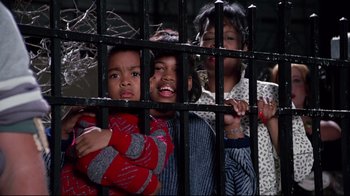 Movie still from “Scrooged” (1988), directed by Richard Donner – A group of children standing next to each other behind a fence; Close Up shot, Low angle