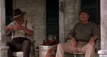 Movie still from “Secondhand Lions” (2003), directed by Tim McCanlies – Two men sitting on a chair with drinks on a table; Medium shot, Low angle