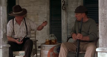 Movie still from “Secondhand Lions” (2003), directed by Tim McCanlies – Two men sitting on a porch with a drink; Medium shot, Low angle
