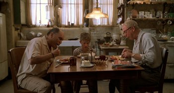 Movie still from “Secondhand Lions” (2003), directed by Tim McCanlies – A group of people sitting around a table eating food; Wide shot, High angle