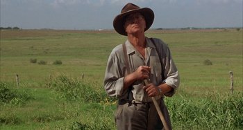 Movie still from “Secondhand Lions” (2003), directed by Tim McCanlies – An older man in a hat holding a stick in a field; Medium shot, Low angle