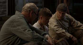 Movie still from “Secondhand Lions” (2003), directed by Tim McCanlies – A group of men sitting next to each other on a bench; Medium shot, Over the shoulder angle