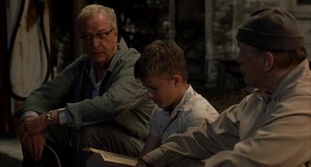 Movie still from “Secondhand Lions” (2003), directed by Tim McCanlies – A group of people sitting around a room reading books; Medium shot, Over the shoulder angle