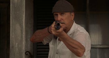 Movie still from “Secondhand Lions” (2003), directed by Tim McCanlies – A man holding a gun while wearing a hat; Close Up shot, Low angle