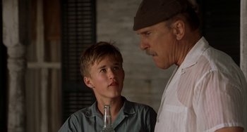 Movie still from “Secondhand Lions” (2003), directed by Tim McCanlies – A man and a young boy standing next to each other; Close Up shot, Low angle